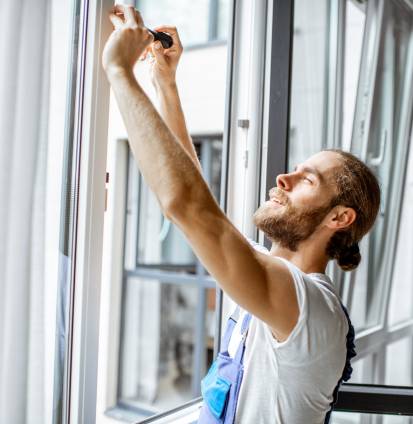 Workman adjusting window frames at home Trabajador ajustando los marcos de las ventanas en casa - Puertas y ventanas de pvc Termprotect